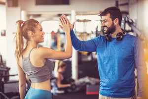 healthy man and woman high five for taking nitric oxide supplements